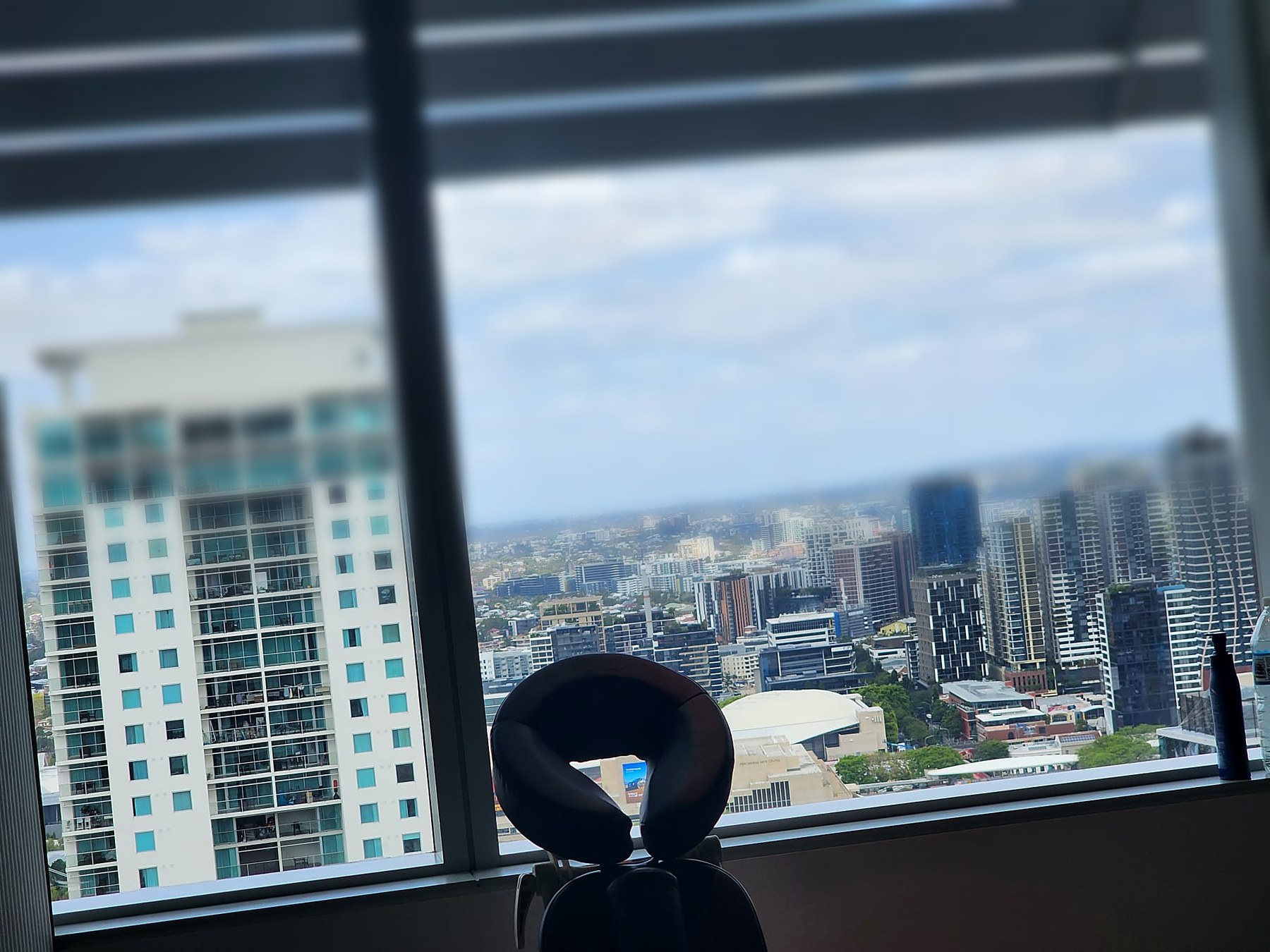 On-site corporate massage — chair set up against Brisbane skyline views